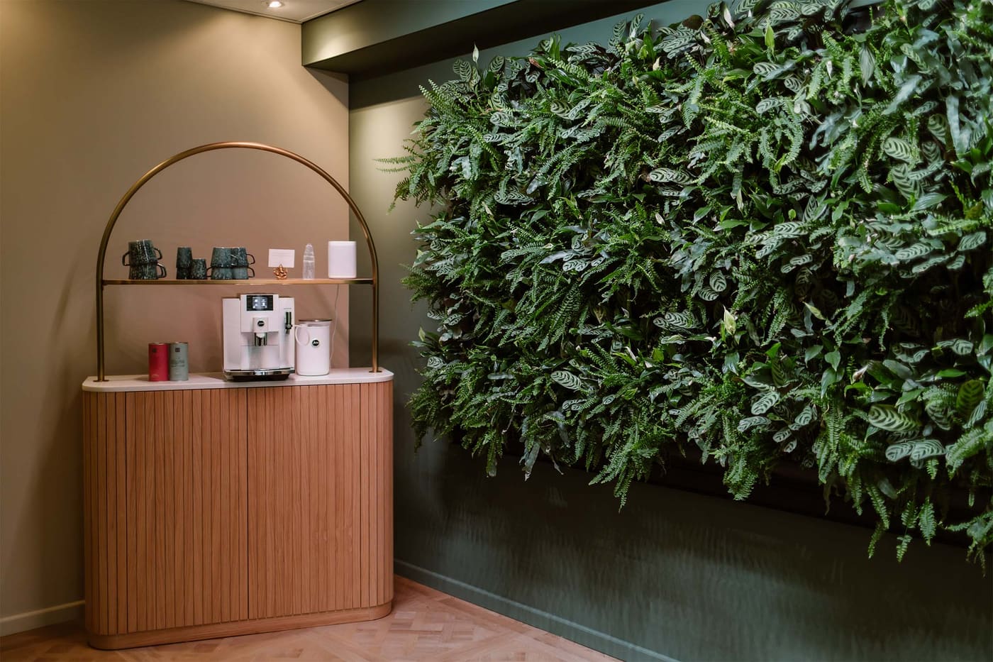 De koffiehoek van de Spa Lounge met boog en plantenwand